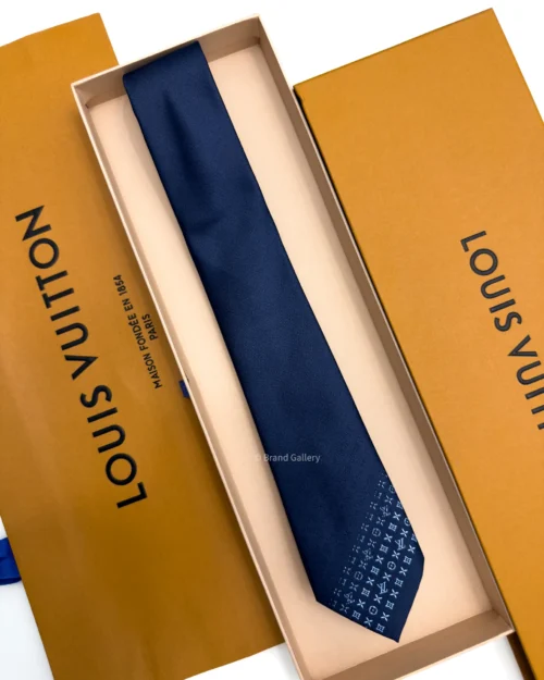 Blue silk tie with tonal geometric pattern and light blue detailing near the tip