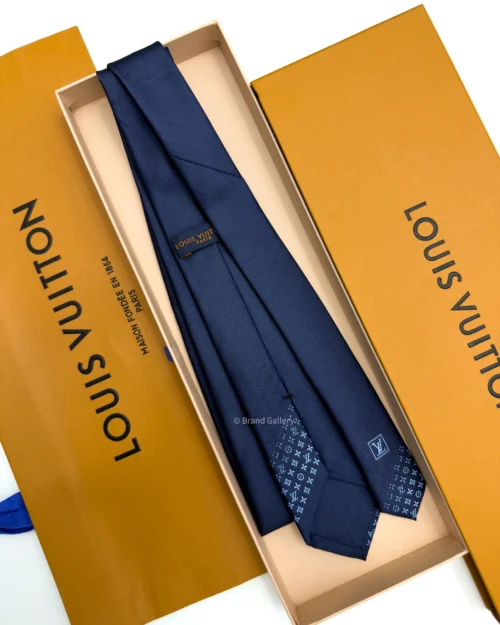 Blue silk tie with tonal geometric pattern and light blue detailing near the tip