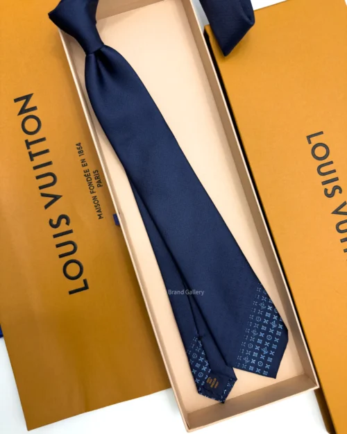 Blue silk tie with tonal geometric pattern and light blue detailing near the tip