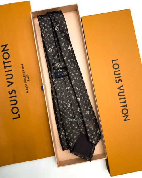 Dark brown silk tie with repeating light beige geometric pattern and textured weave