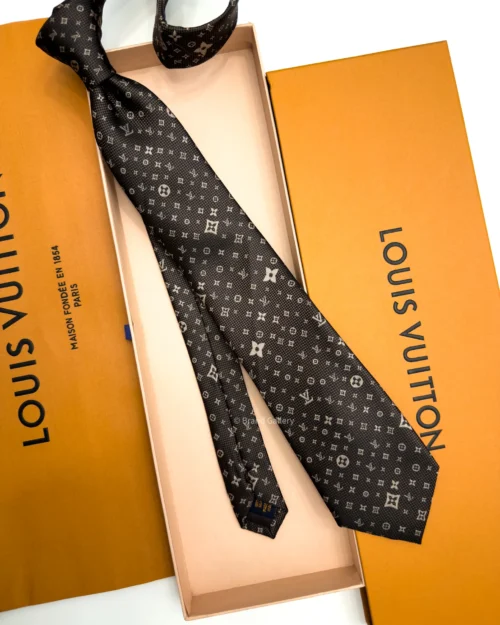 Dark brown silk tie with repeating light beige geometric pattern and textured weave