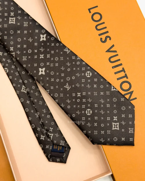 Dark brown silk tie with repeating light beige geometric pattern and textured weave