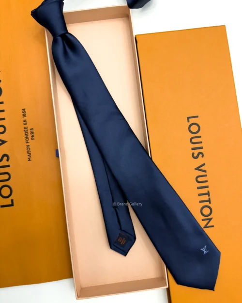 Navy blue solid silk tie with subtle light blue motif near the tip