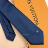 Navy blue solid silk tie with subtle light blue motif near the tip